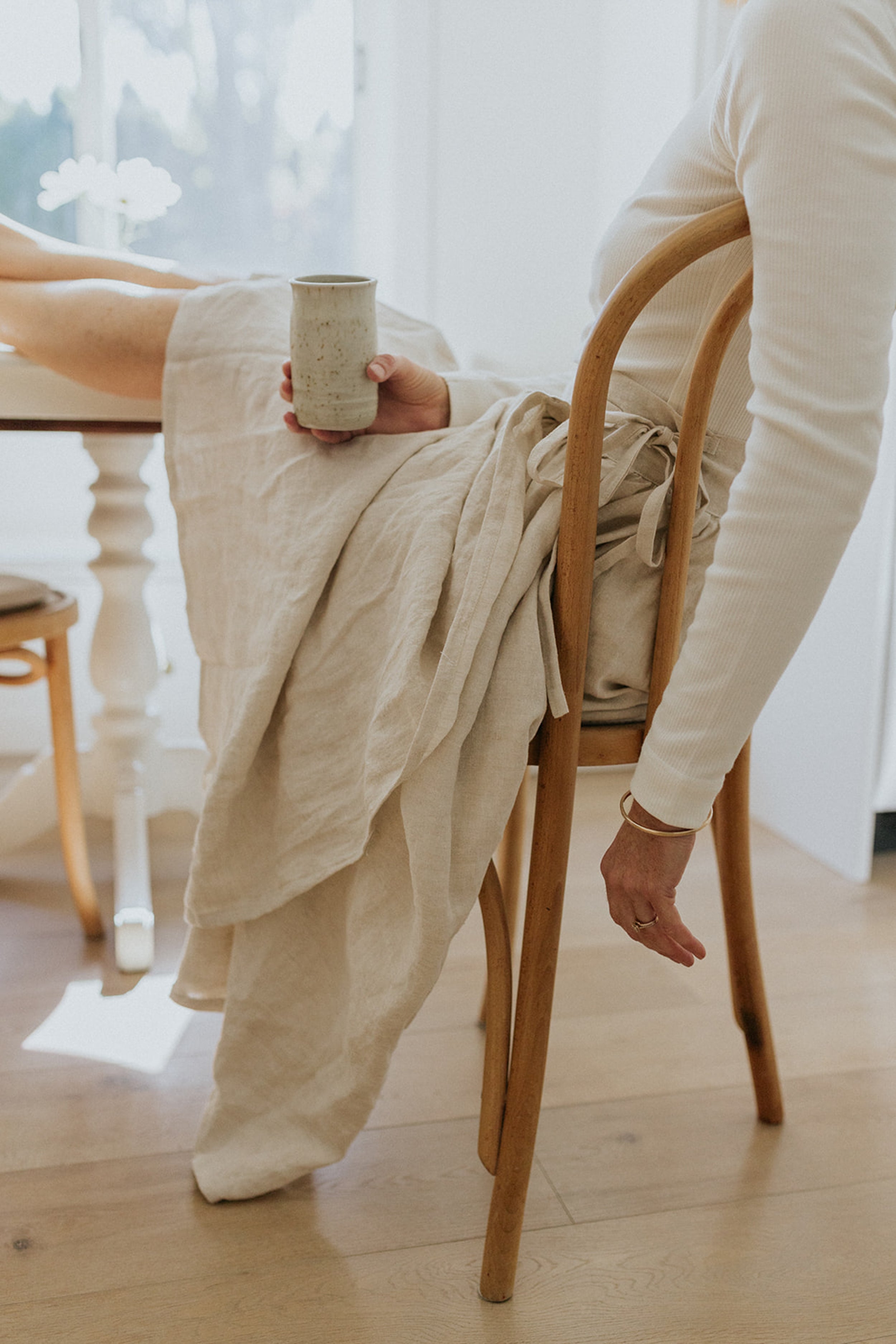 Woman sitting with coffee wearing Breta Wrap Skirt by Peplum Co